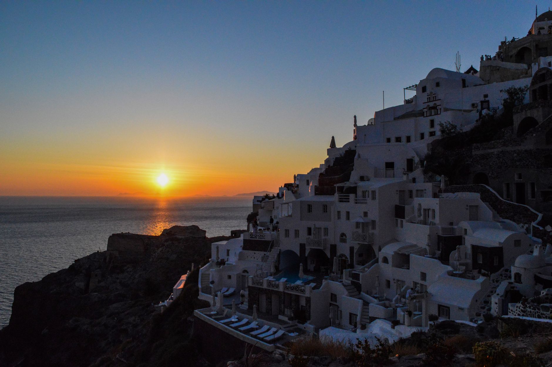Whitewashed Santorini houses overlooking the caldera at sunset